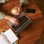 a man using a laptop with a coffe in his hand